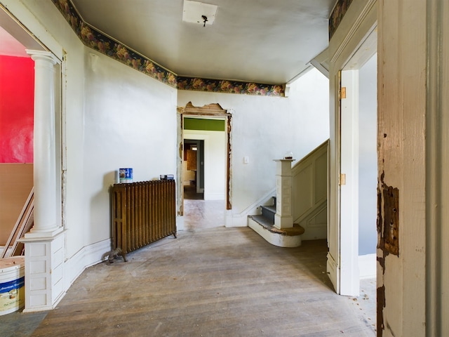 hall with hardwood / wood-style flooring and decorative columns