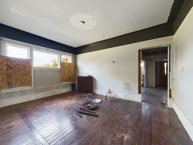 spare room with radiator and dark wood-type flooring