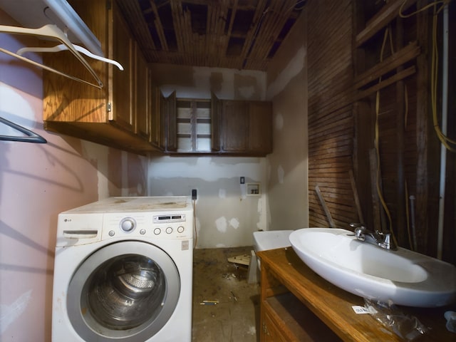 clothes washing area featuring washer / clothes dryer and sink