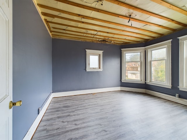 spare room featuring beam ceiling, wood-type flooring, and wood ceiling