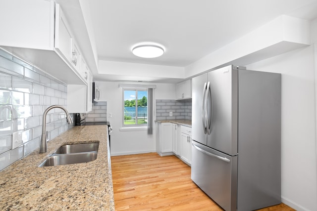 1794 S Hughes Rd, Brighton, MI 48114 - kitchen featuring stainless steel appliances, white cabinetry, tasteful backsplash, and light stone counters