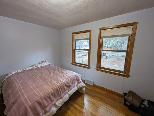 42294 Willson Memorial Dr, Chassell, MI 49916 - bedroom featuring wood-type flooring, baseboards, and a textured ceiling