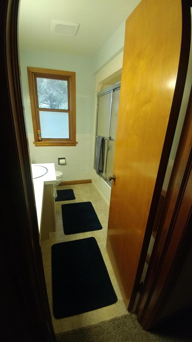 42294 Willson Memorial Dr, Chassell, MI 49916 - full bath featuring vanity, a wainscoted wall, toilet, and enclosed tub / shower combo