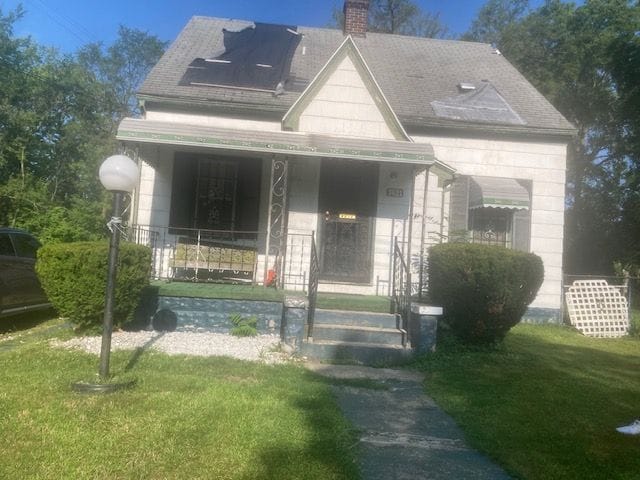 view of front of property featuring covered porch and a front yard