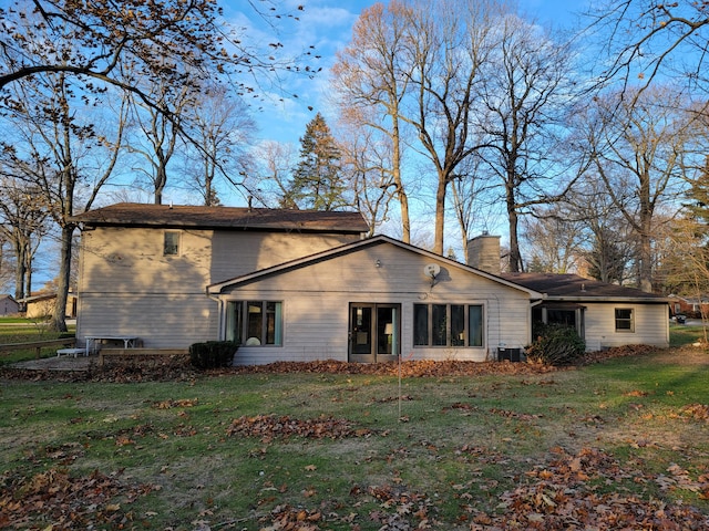 rear view of property featuring a yard and central AC unit