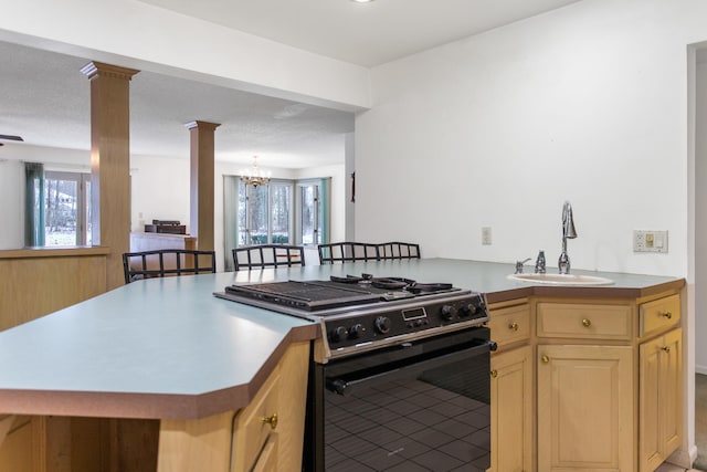 kitchen with sink, high end stove, kitchen peninsula, a breakfast bar area, and a chandelier