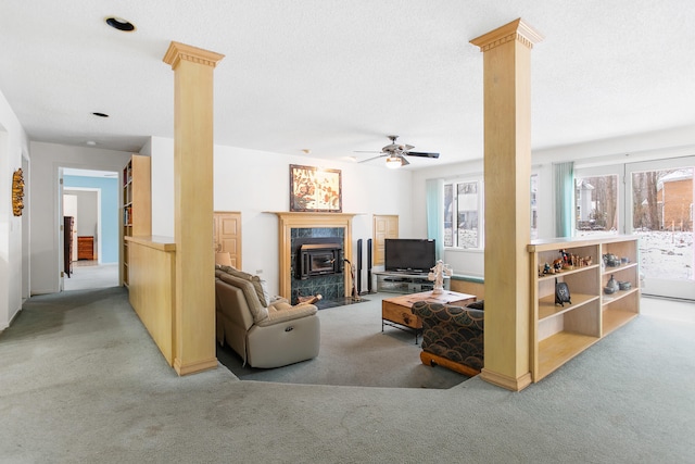 living room featuring ornate columns, light carpet, ceiling fan, and a textured ceiling