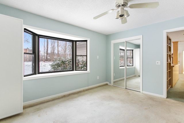 unfurnished bedroom with multiple windows, ceiling fan, and light carpet