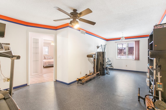 exercise area with a textured ceiling and ceiling fan