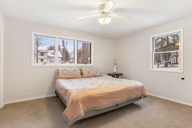 carpeted bedroom with multiple windows and ceiling fan