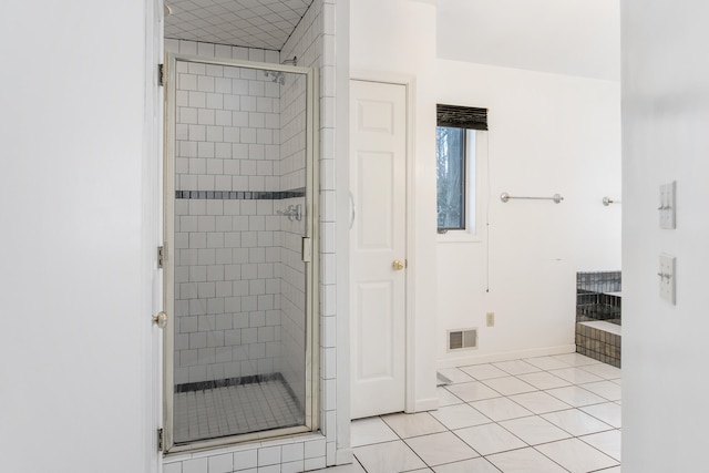 bathroom with tile patterned floors and a shower with door