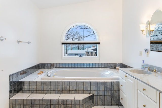 bathroom featuring vanity, lofted ceiling, and tiled bath