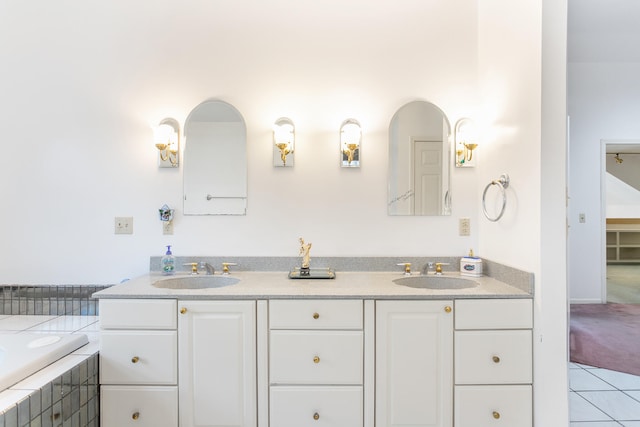 bathroom featuring tile patterned flooring, vanity, and a relaxing tiled tub