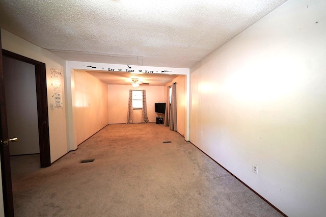 hallway with carpet flooring and a textured ceiling