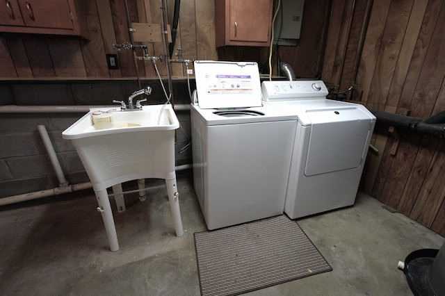 laundry room featuring wooden walls, cabinets, and washer and dryer