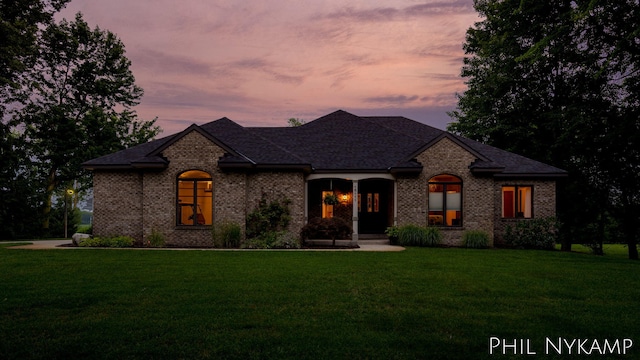 15111 Ransom St, Holland, MI 49424 - french country inspired facade featuring a front yard, brick siding, a porch, and a shingled roof