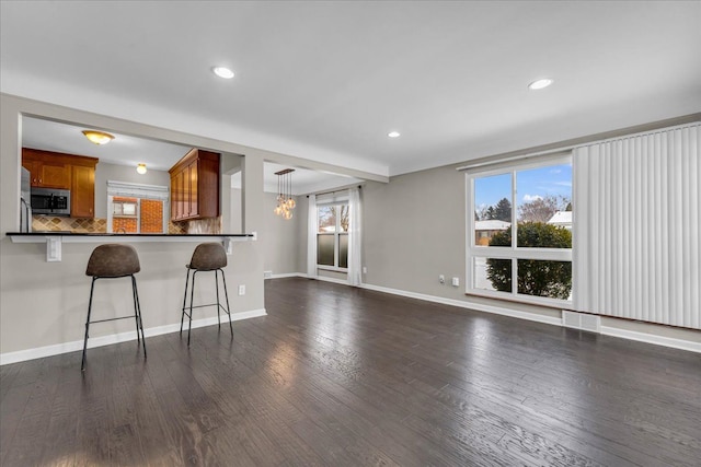 interior space with dark wood-type flooring, a wealth of natural light, and a notable chandelier