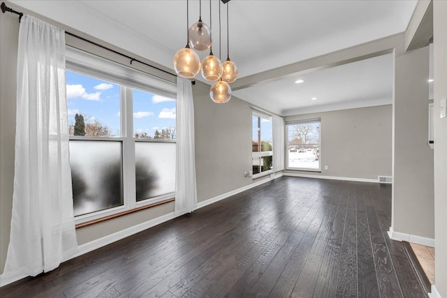 spare room featuring dark hardwood / wood-style floors and a notable chandelier