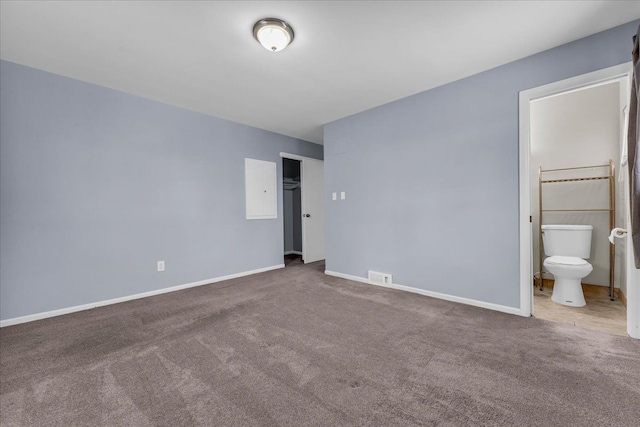 unfurnished bedroom featuring ensuite bath and carpet flooring