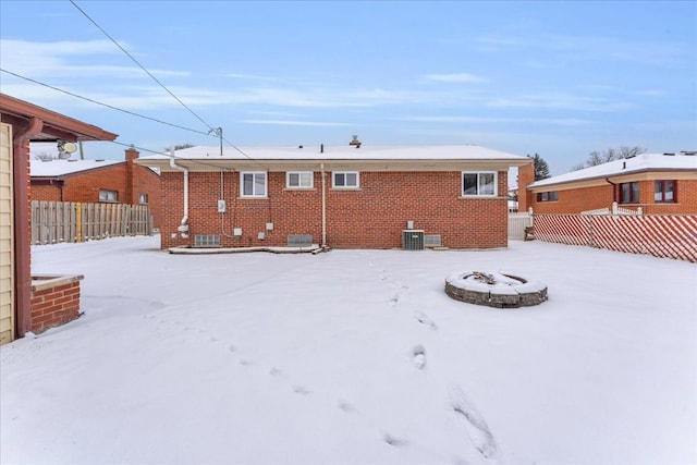 snow covered house featuring central AC