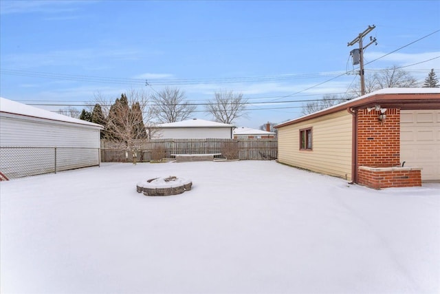 yard covered in snow featuring a fire pit