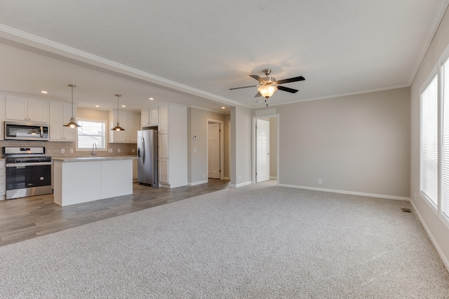 unfurnished living room featuring ceiling fan, light hardwood / wood-style floors, and crown molding