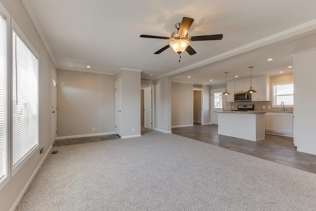 unfurnished living room with wood-type flooring, ceiling fan, and crown molding