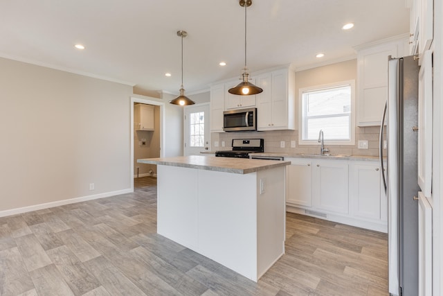 kitchen featuring pendant lighting, a center island, white cabinets, sink, and appliances with stainless steel finishes