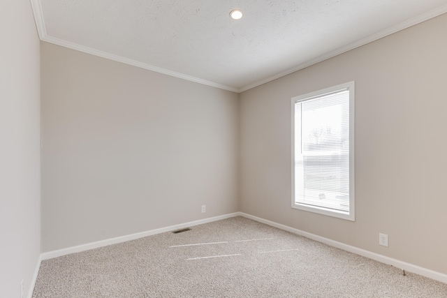 carpeted spare room featuring a textured ceiling and ornamental molding