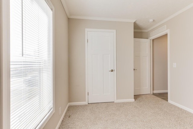 unfurnished bedroom featuring ornamental molding, light carpet, and a closet