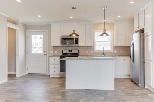 kitchen featuring white cabinetry, plenty of natural light, pendant lighting, and appliances with stainless steel finishes