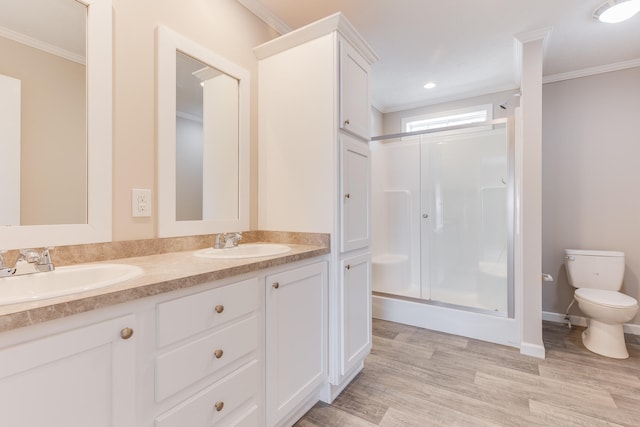 bathroom featuring ornamental molding, vanity, hardwood / wood-style flooring, toilet, and a shower with shower door