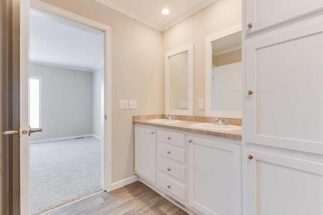 bathroom with crown molding, hardwood / wood-style floors, and vanity