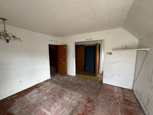 empty room with an inviting chandelier and lofted ceiling