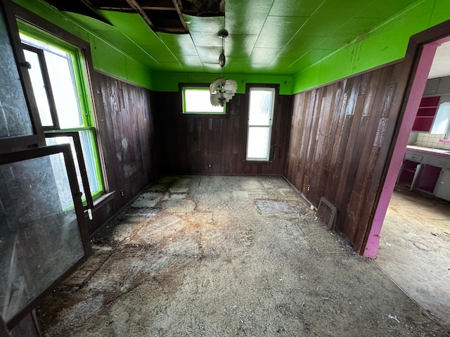 unfurnished room featuring wood walls