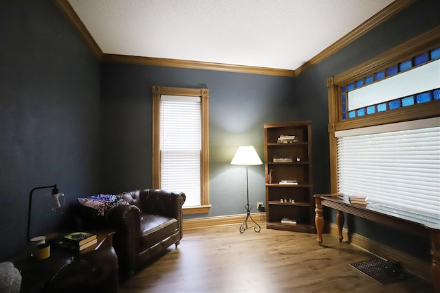 sitting room featuring wood-type flooring and ornamental molding