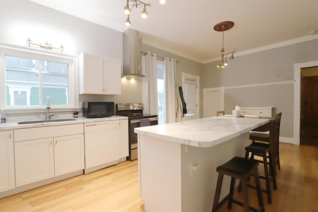 kitchen with dishwasher, a center island, wall chimney range hood, sink, and electric range