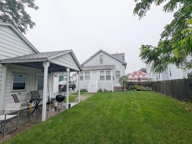 back of house with a patio area and a yard