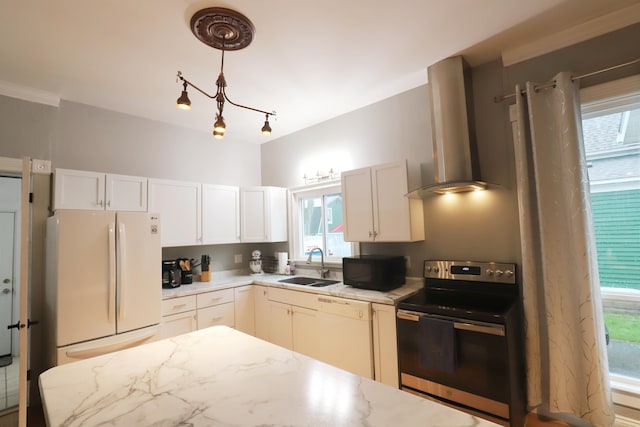 kitchen with sink, wall chimney range hood, light stone counters, white appliances, and white cabinets