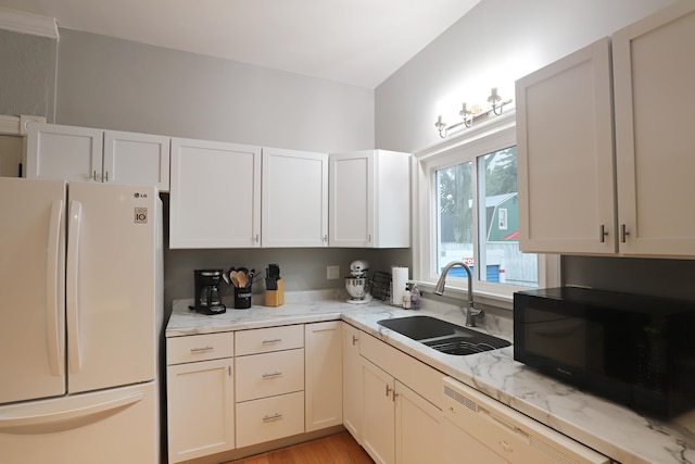 kitchen with light stone countertops, sink, light hardwood / wood-style floors, and white appliances