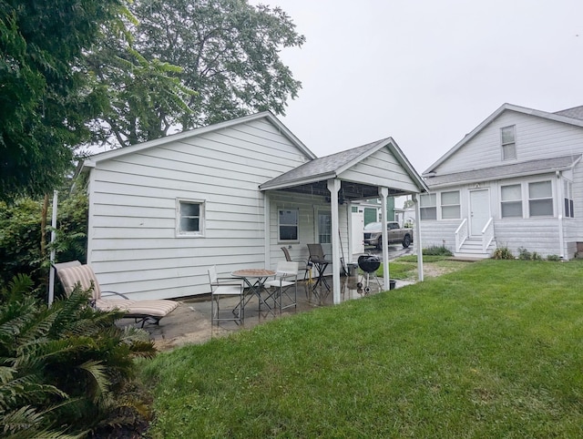 rear view of house featuring a yard and a patio