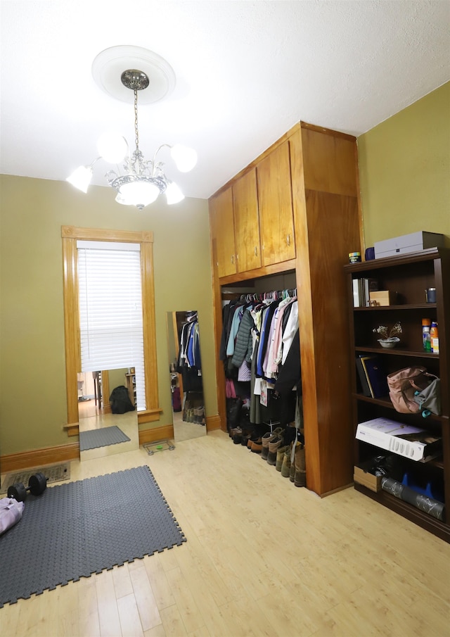 mudroom featuring light hardwood / wood-style flooring and a chandelier