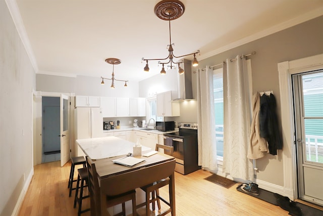 kitchen featuring light wood-type flooring, white cabinetry, stainless steel electric stove, and a healthy amount of sunlight