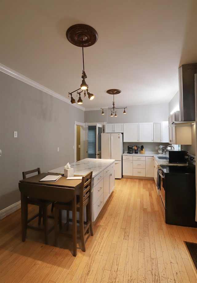 kitchen with ventilation hood, white refrigerator, white cabinets, light hardwood / wood-style floors, and hanging light fixtures