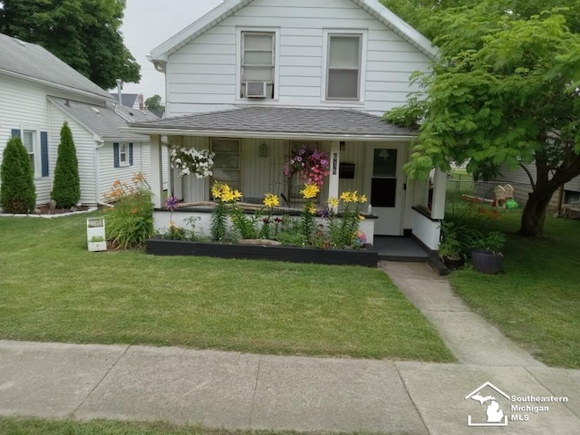 view of front facade with cooling unit, a front lawn, and a porch