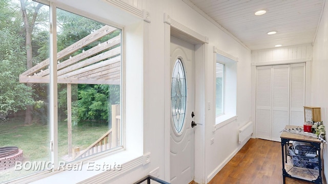 foyer with plenty of natural light, dark hardwood / wood-style flooring, and ornamental molding