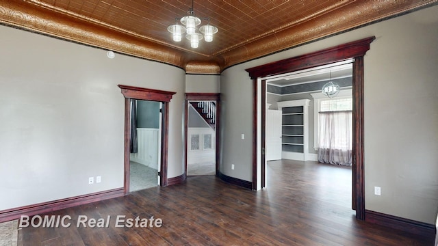 spare room featuring a chandelier and dark hardwood / wood-style floors