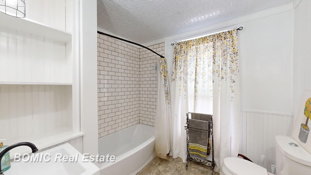 full bathroom featuring shower / bath combination with curtain, toilet, wooden walls, and sink