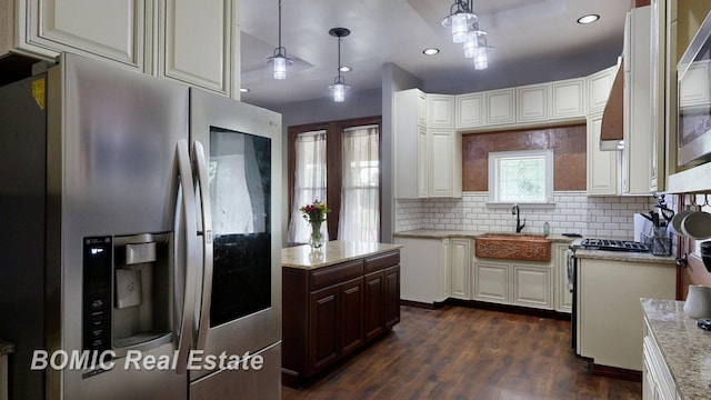 kitchen with decorative backsplash, dark wood-type flooring, sink, decorative light fixtures, and stainless steel fridge with ice dispenser