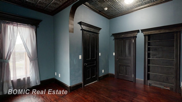 interior space with dark wood-type flooring and ornamental molding